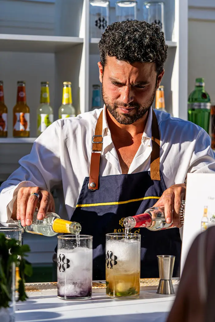 A man in an apron making drinks at a bar